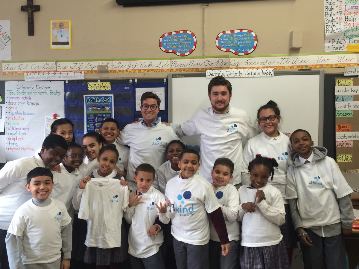 A group of people standing in front of some kids.