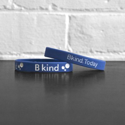 A blue bracelet with the words " b kind ".