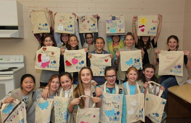 A group of young people holding bags with messages on them.