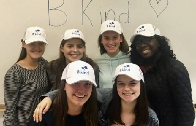 A group of people wearing hats and smiling.