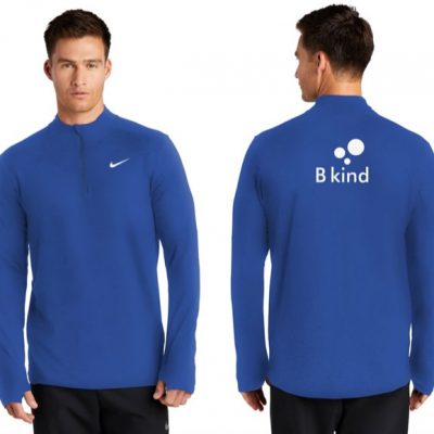 A man wearing a blue nike shirt with the word " b kind " on it.